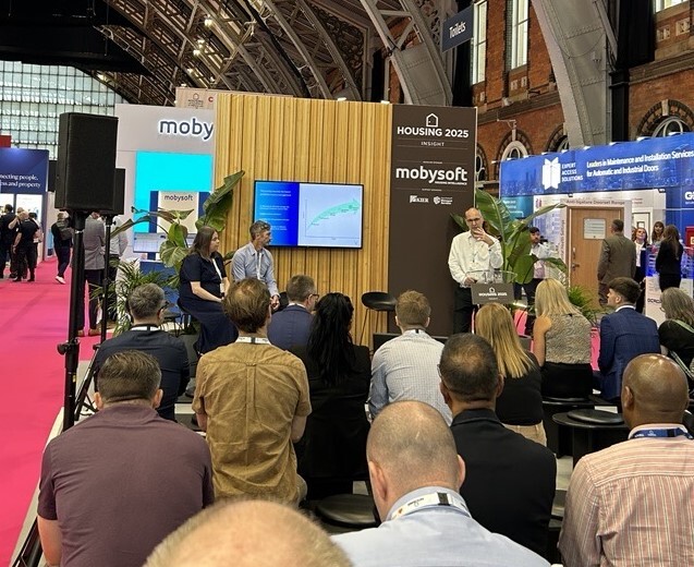 A photograph of the Voicescape team doing a talk in the Housing 25 conference hall