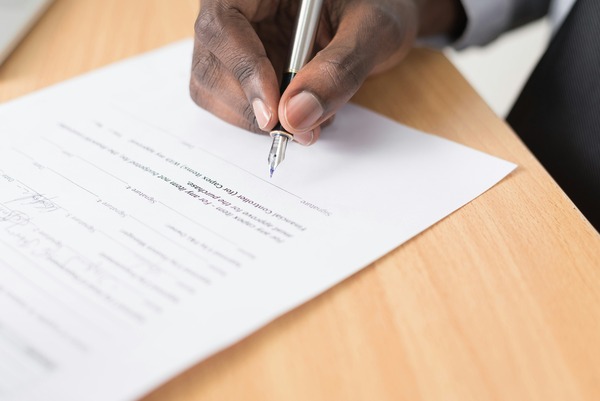 Person writing on a Tenancy Repayment Agreement